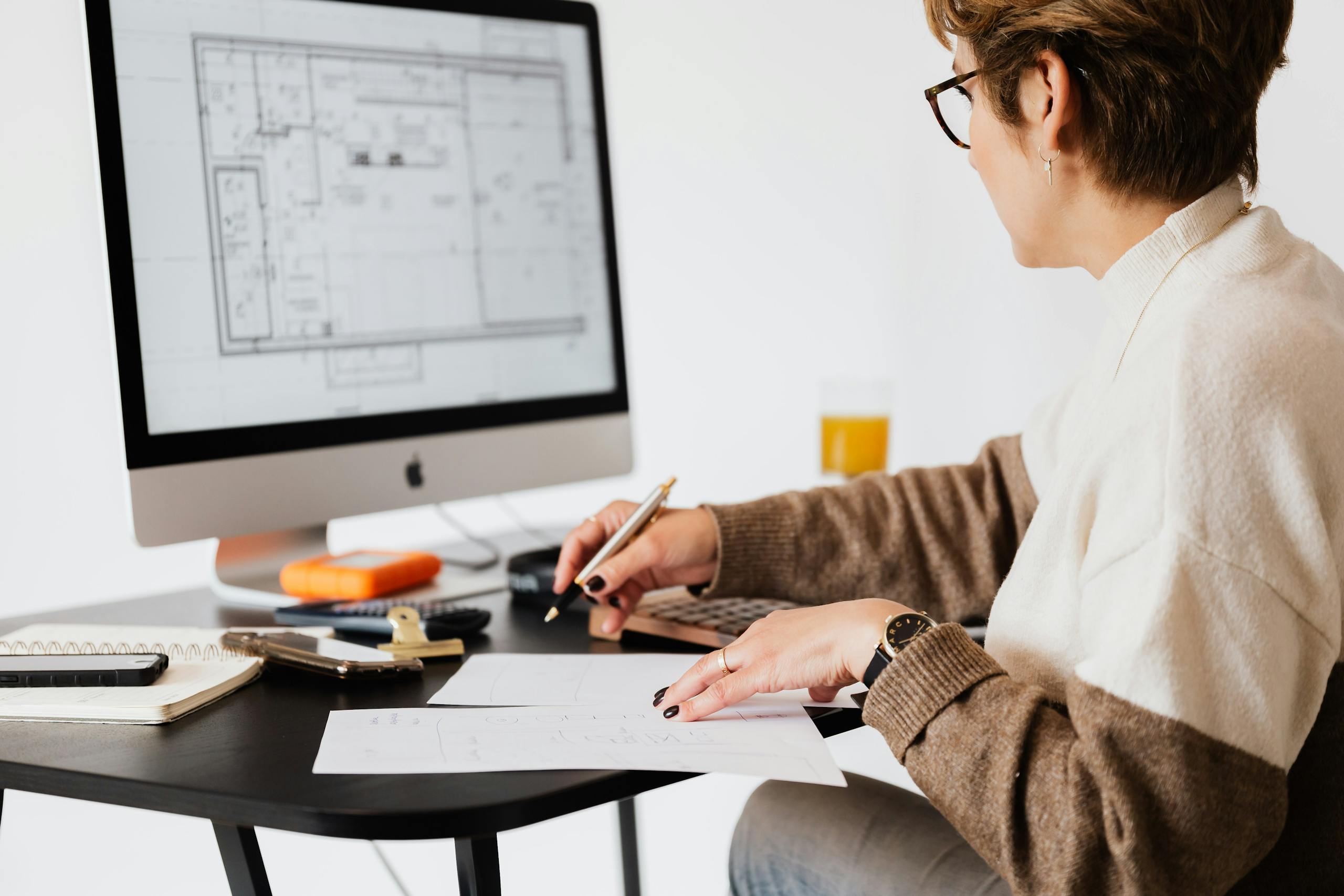Floor Plan designing architectural blueprints using desktop computer in a modern office setting.